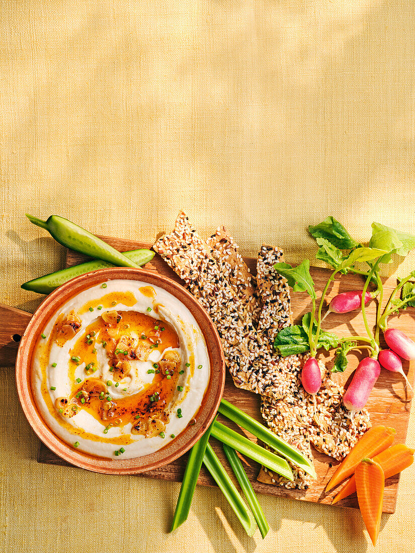 Whipped butter bean dip with garlic oil, vegetable sticks and crackers