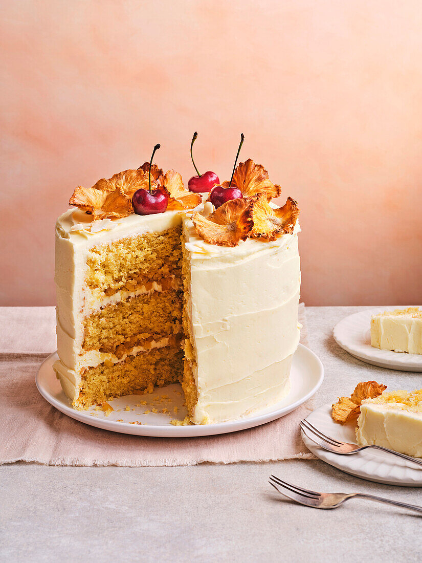 Piña-Colada-Schichtkuchen mit Ananas und Kirschen