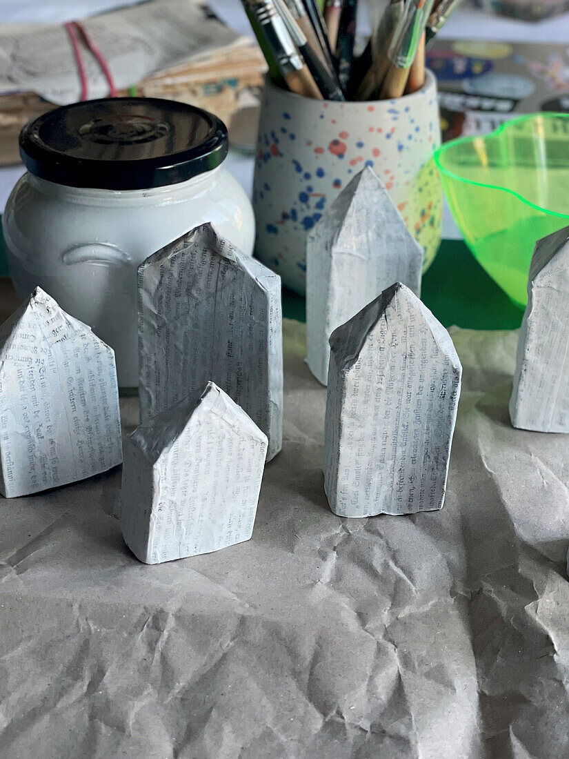 Small houses made from loo rolls and book pages as Christmas decorations