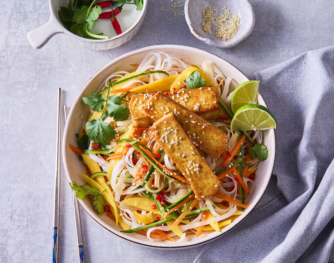 Asia-Nudelsalat mit Mangostreifen, gebratenem Tofu und Koriander