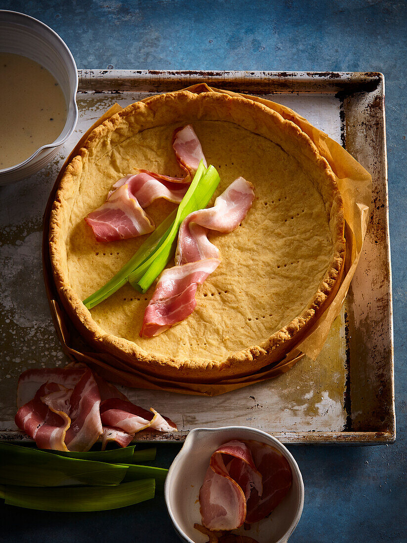 Quiche base with raw ham and leek strips