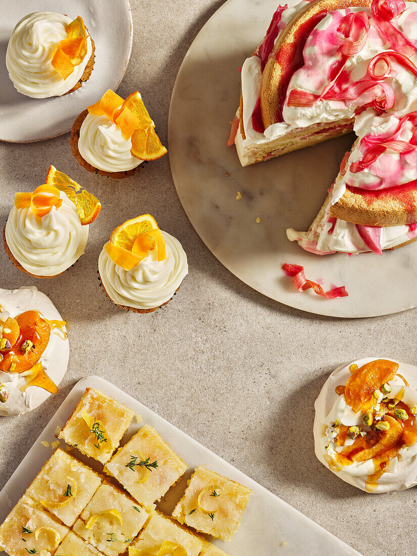 Lemon sponge cake, rhubarb tart and cupcakes with whipped cream topping