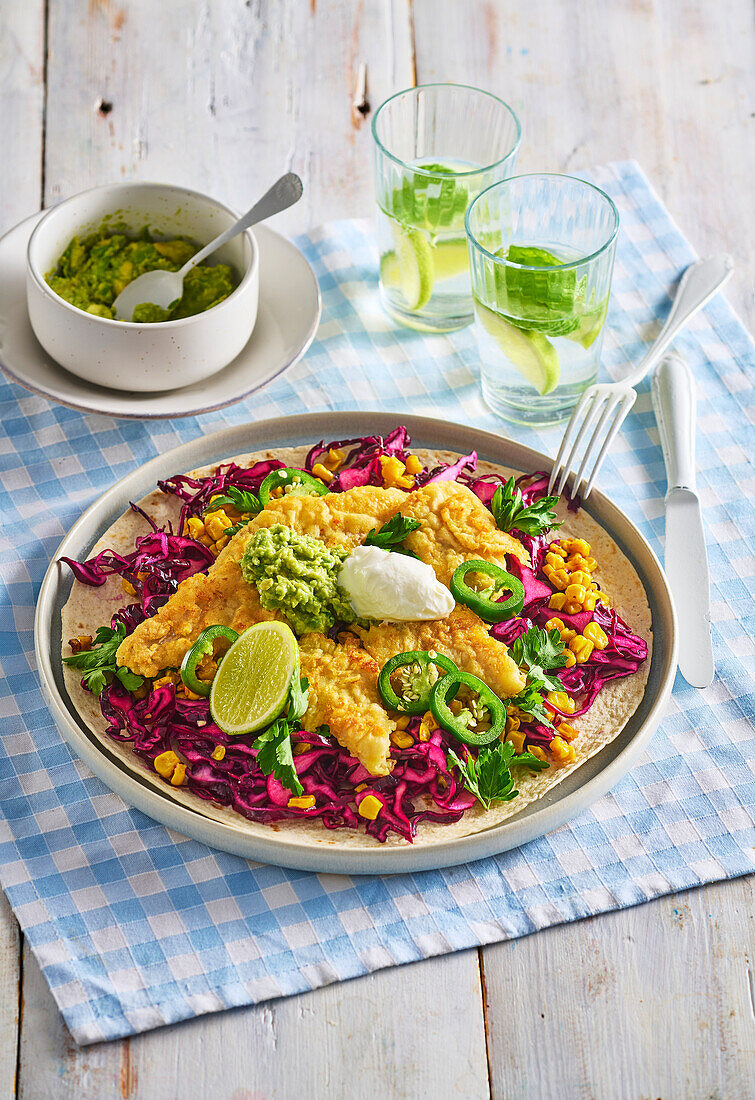 Fish tacos with red cabbage, guacamole and lime