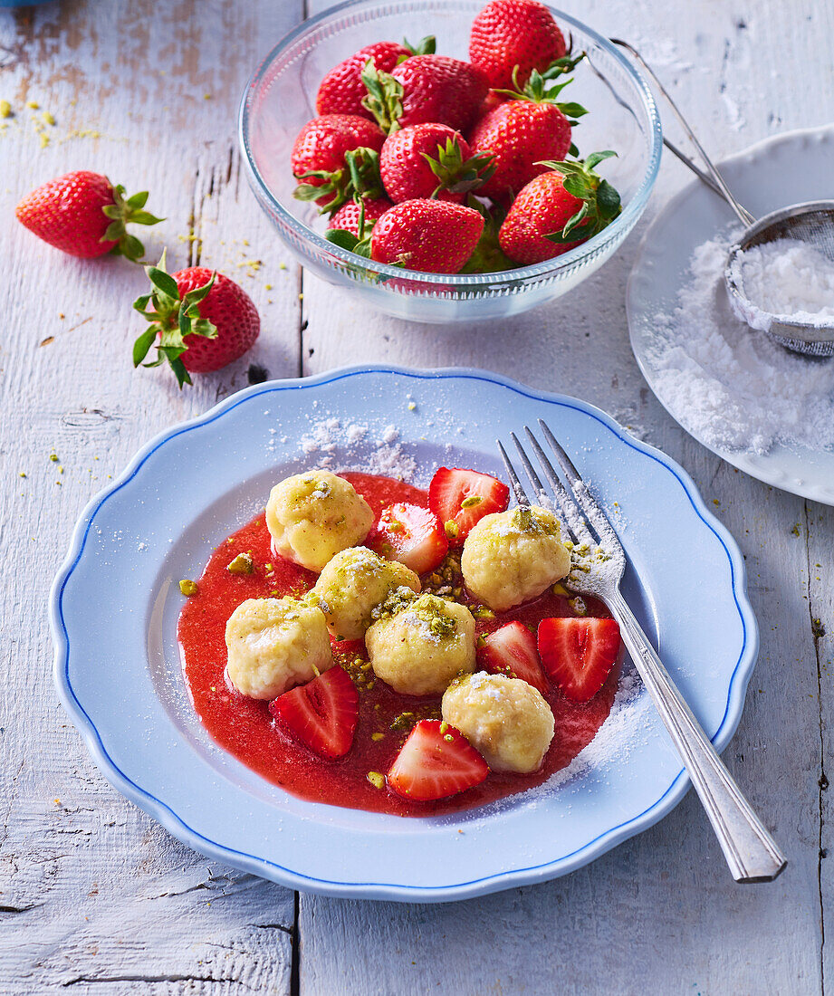 Mini curd cheese dumplings with strawberry sauce and pistachios