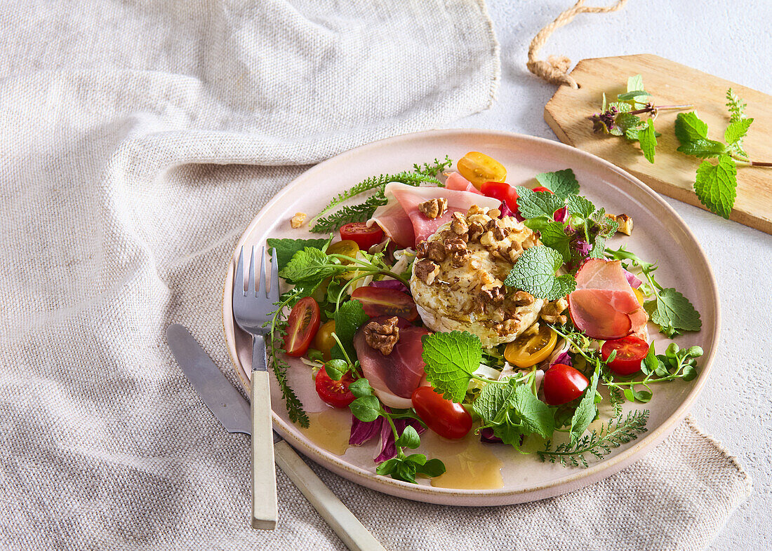 Spring salad with herbs, grilled camembert and ham