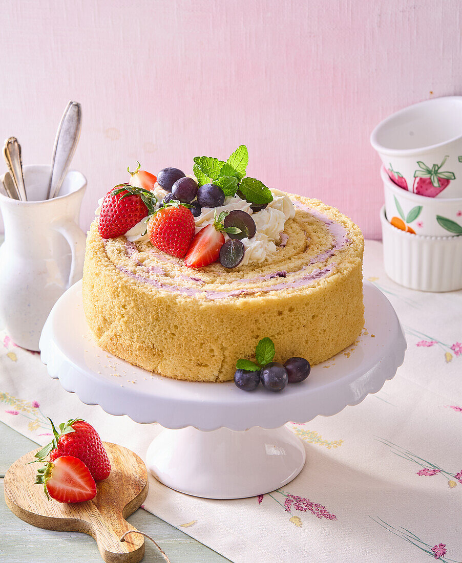 Sponge roll cake with strawberries, grapes and cream filling