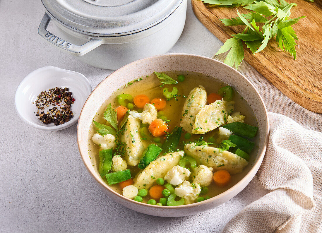 Vegetable soup with cheese gnocchi and fresh herbs