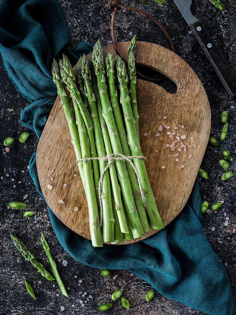 Bund frischer grüner Spargel auf Holzbrett