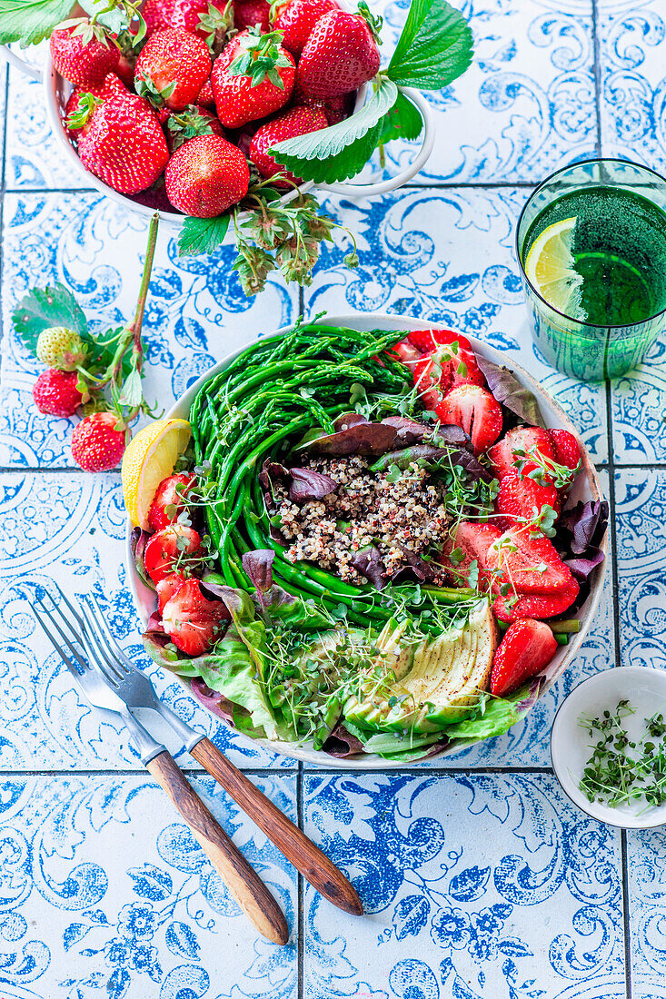 Quinoa bowl with green asparagus, strawberries, and avocado