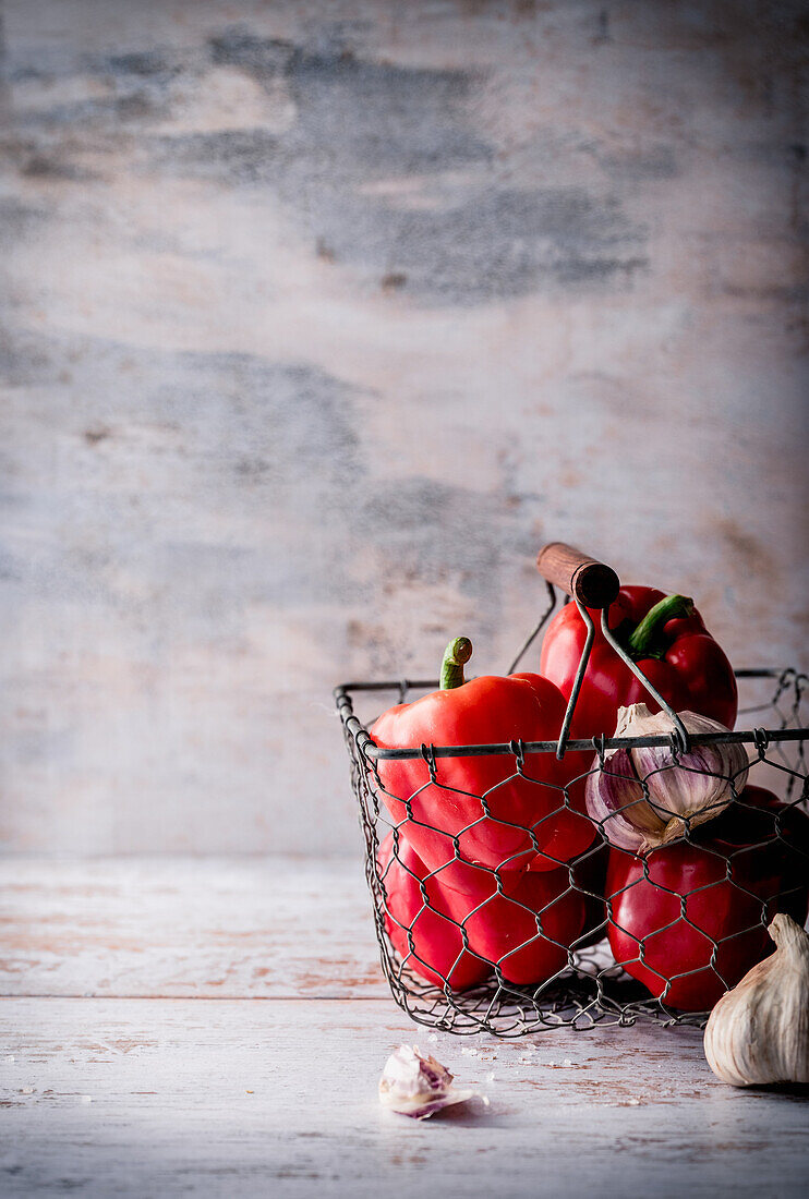 Red peppers and garlic in a wire basket