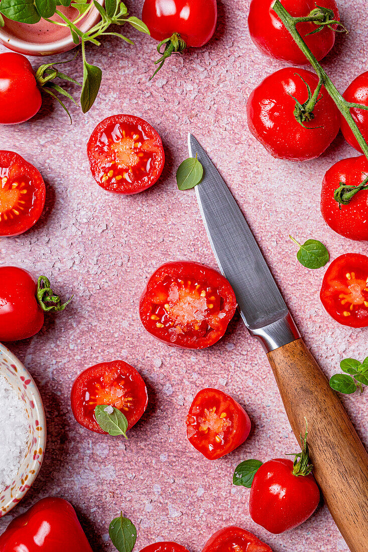 Ganze und halbierte Kirschtomaten mit Messer