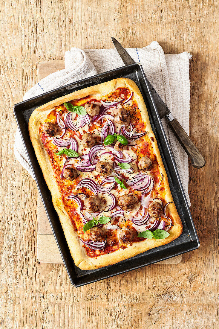 Deep-dish pizza with sausage and red onions