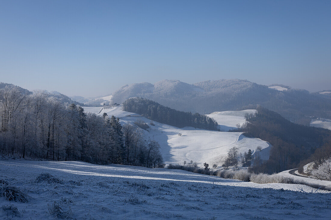 Winter landscape with snow-covered hills and forests in Aargau, Switzerland