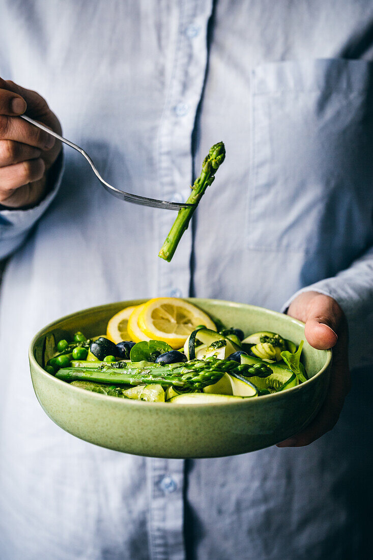 Salad bowl with zucchini, asparagus, cucumber, peas and blueberries