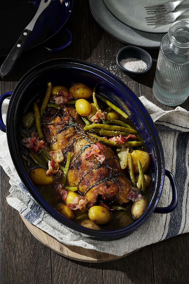 Roast lamb with new potatoes, bacon and beans