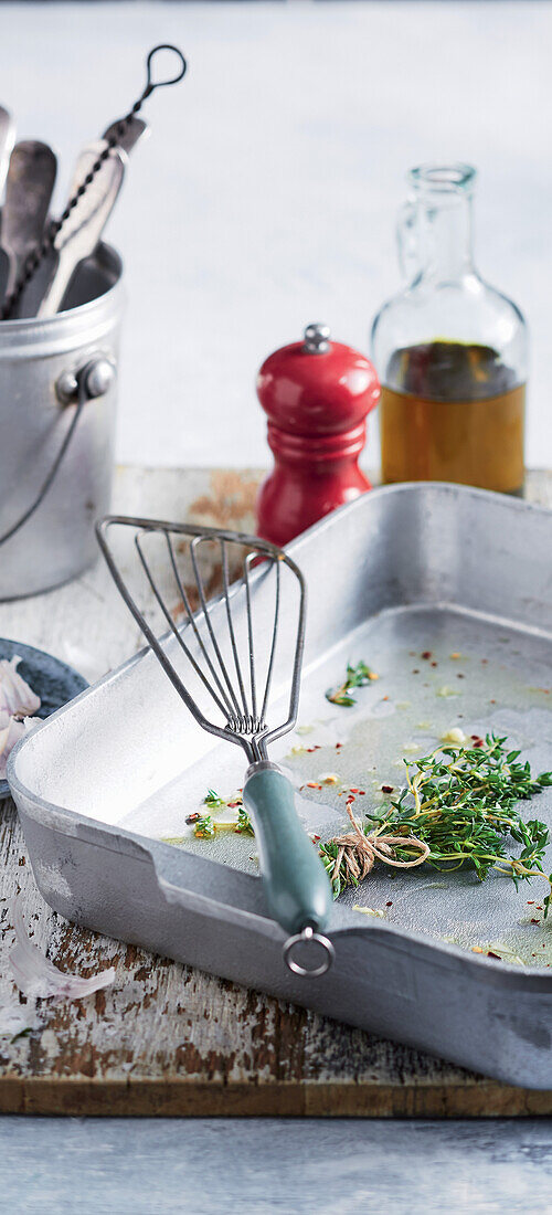 Oven dish with bunches of herbs and oil