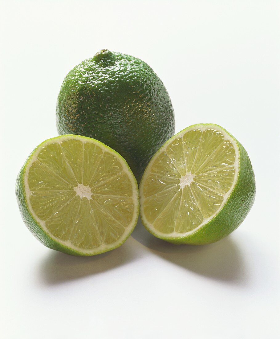 Two lime halves in front of whole lime