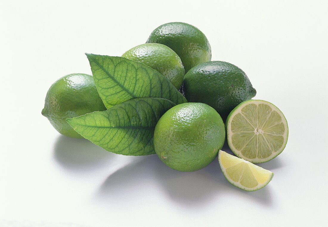 Five limes with leaves, lime half and wedge