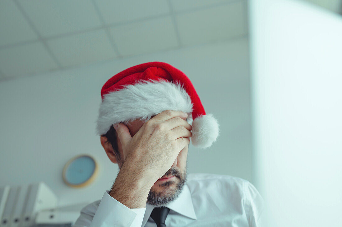 Disappointed businessman with Santa hat