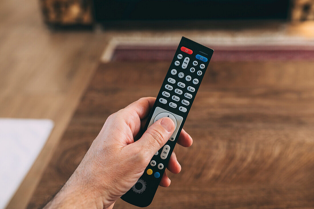 Man using TV remote controller