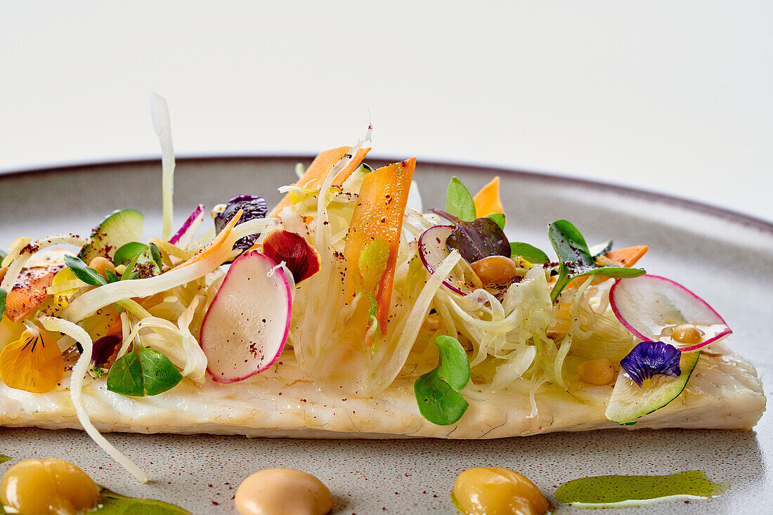 Sea wolf with lemon confit, pine nuts and vegetables