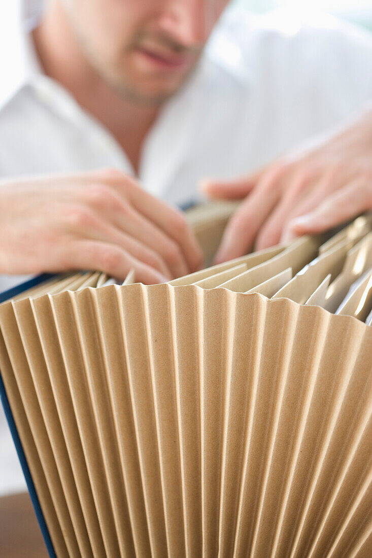 Close up of Businessman Flicking through File Folder