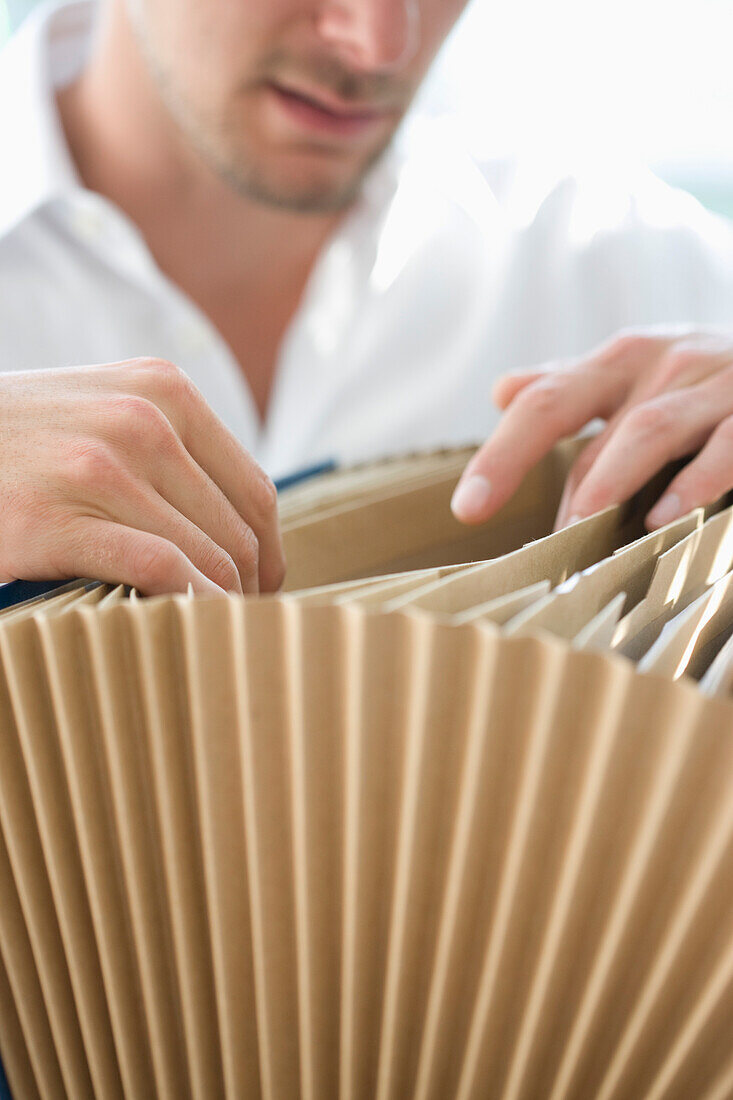 Close up of Businessman Flicking through File Folder