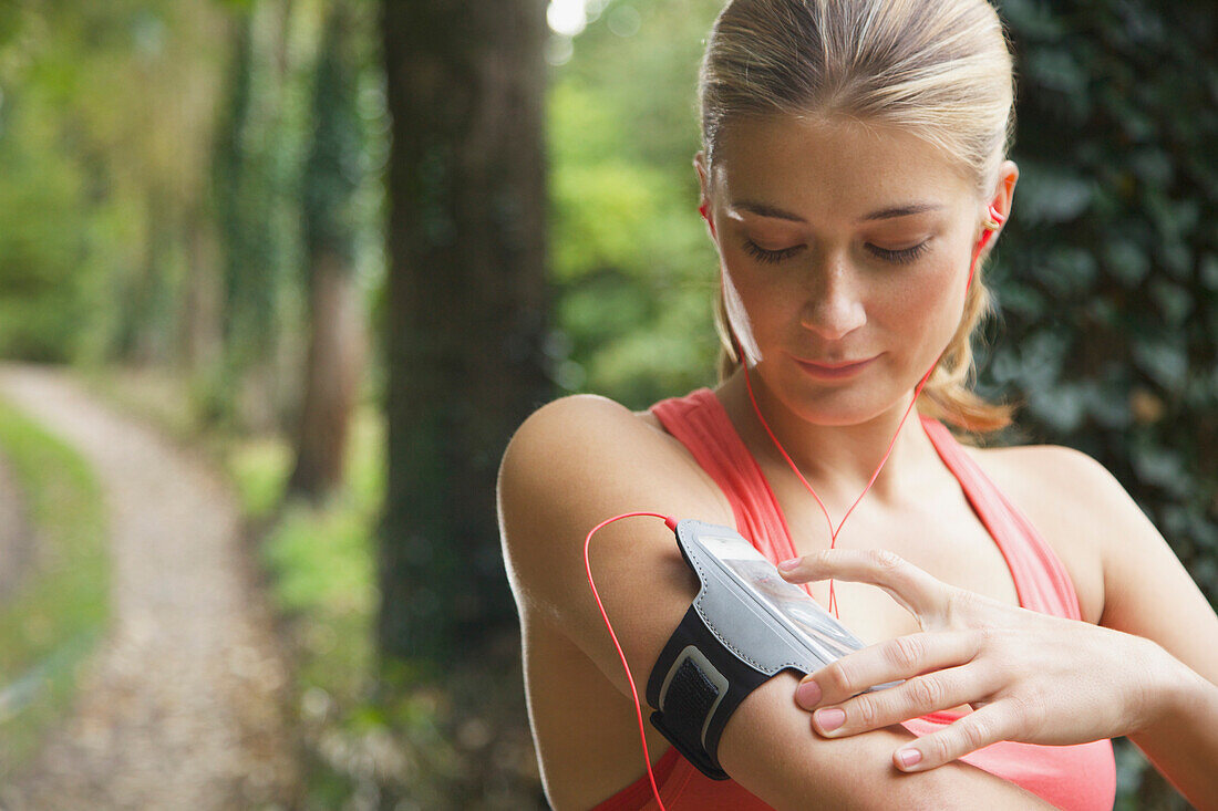 Frau bereitet Mp3-Player für Work-out vor