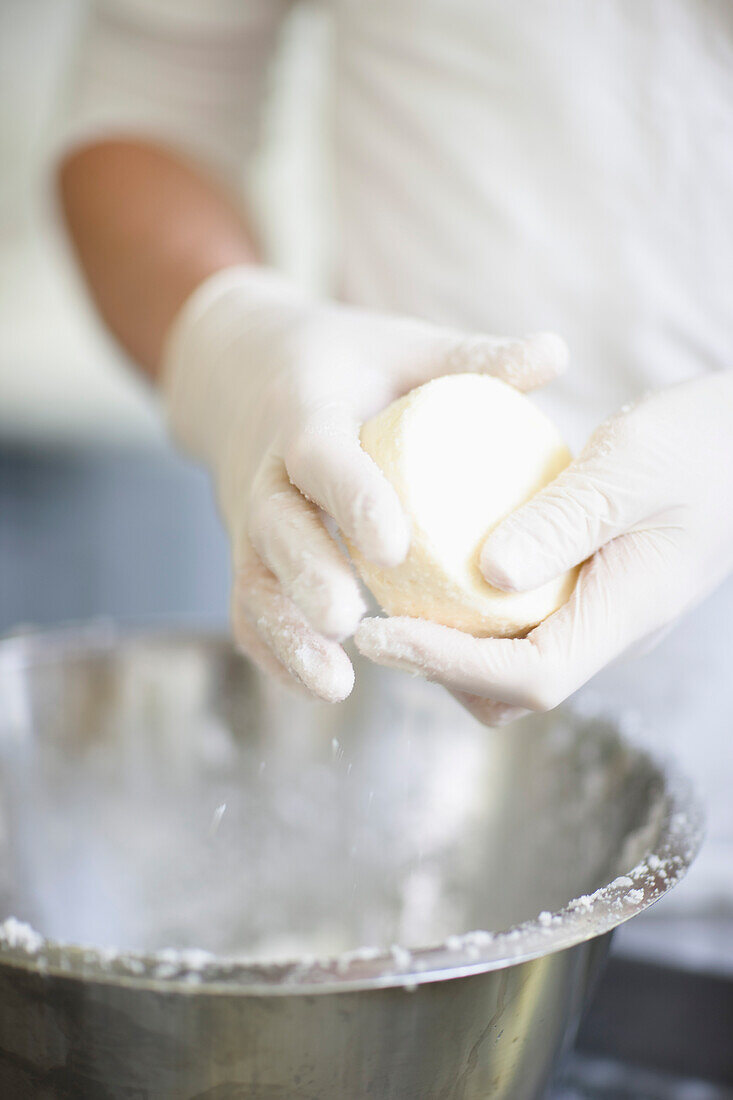 Close up of a man's hands molding cheese