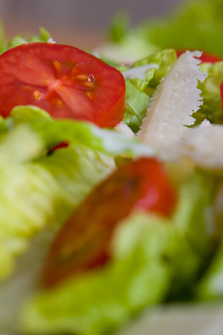 Extreme Nahaufnahme eines gemischten Salats mit Tomaten und Parmesanspänen