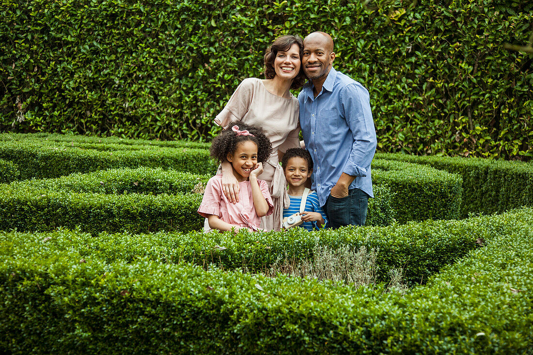 Porträt einer lächelnden Familie im Garten