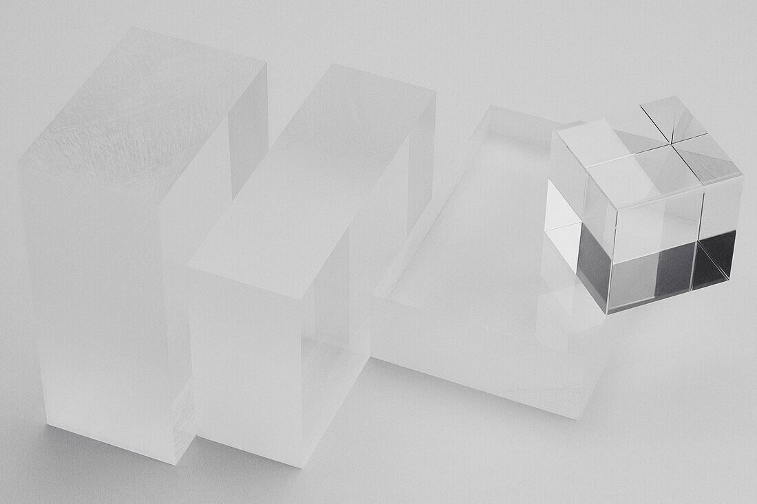 Still life reflective cube on frosted glass block against white background