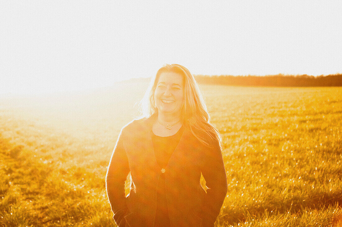 Woman Standing in a Field Smiling