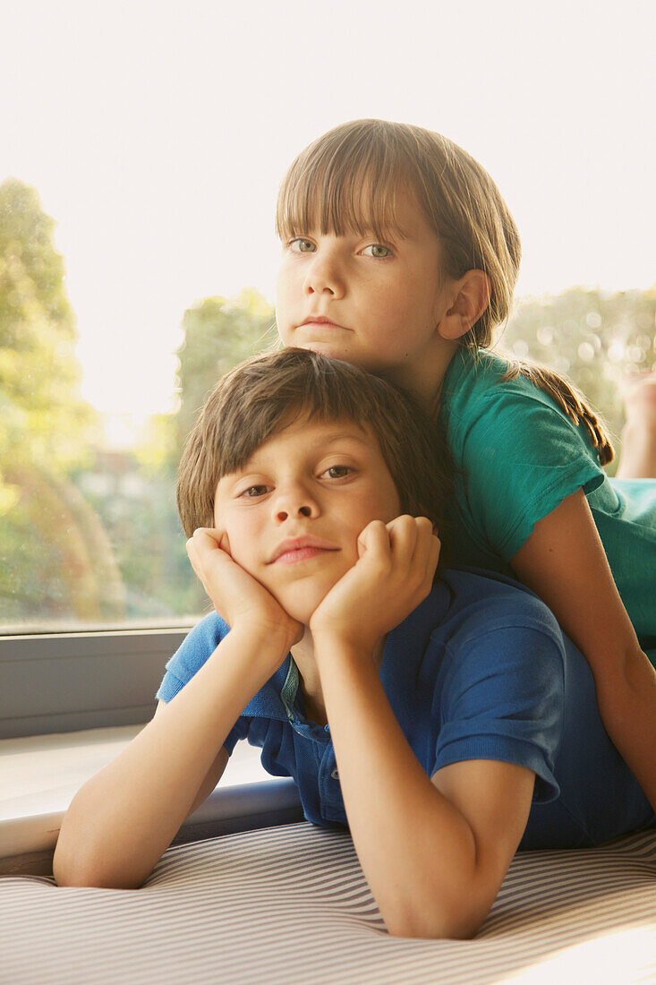 Young Girl Lying on Brother's Back