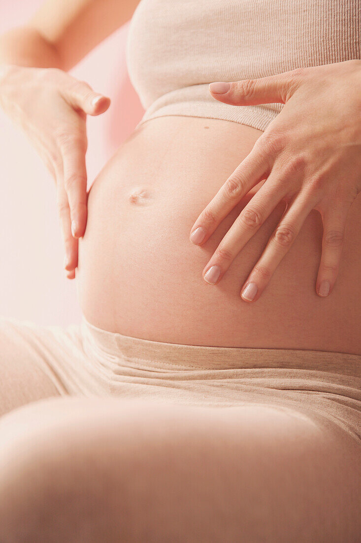 Feathering Therapeutic Massage, Pregnant Woman Massaging her Stomach