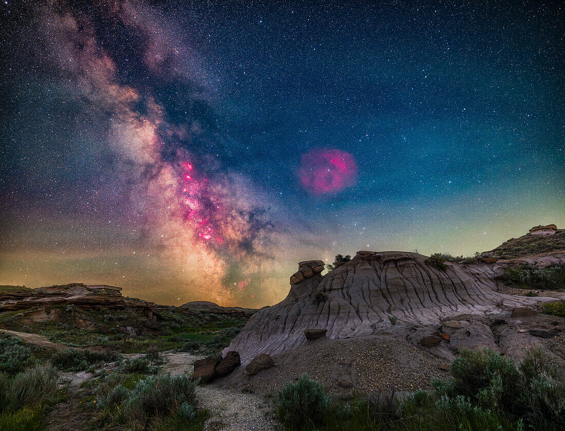 Die Milchstraße und ihre Kernregion in Sagittarius und Scorpius steht hier tief über der Badlands-Landschaft des Dinosaur Provincial Park, Alberta. Dies war in der Nacht vom 31. Mai auf den 1. Juni 2024, als der Himmel auf diesem Breitengrad von 50° 45' N selbst mitten in der Nacht, hier gegen 2:30 Uhr MEZ, noch nicht völlig dunkel ist. Der Himmel behält also eine blaue Färbung.