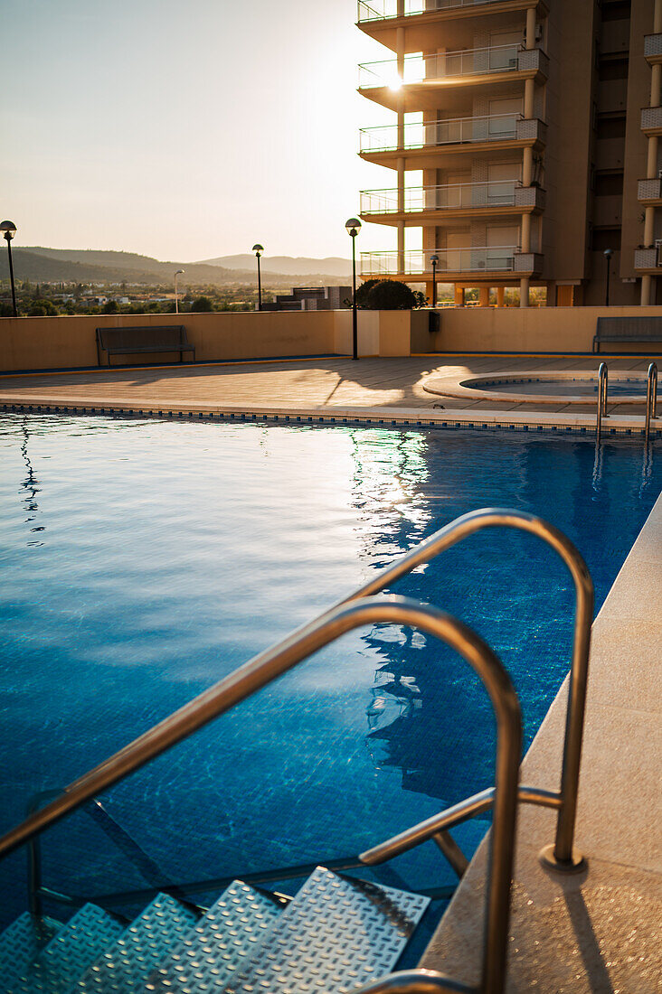 Pool in einer privaten Wohnanlage in Peñiscola bei Sonnenuntergang, Castellon, Valencianische Gemeinschaft, Spanien