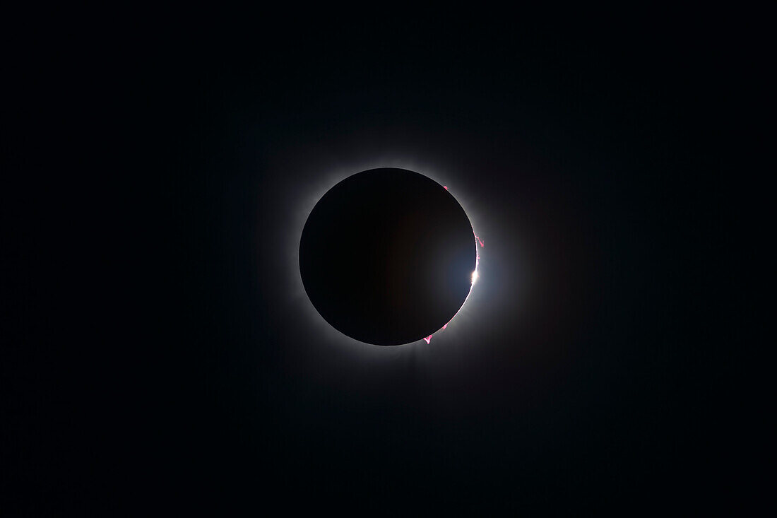 This is a single exposure of the end of totality (Third Contact or C3) of the April 8, 2024 total eclipse of the Sun. It shows the numerous pink prominences along that limb of the Sun and shows the first burst of light from the Sun's photosphere shining through a lunar valley or crater. The bright inner corona also shows up even at this short single exposure. High cirrus clouds added some glow to the diamond ring burst.