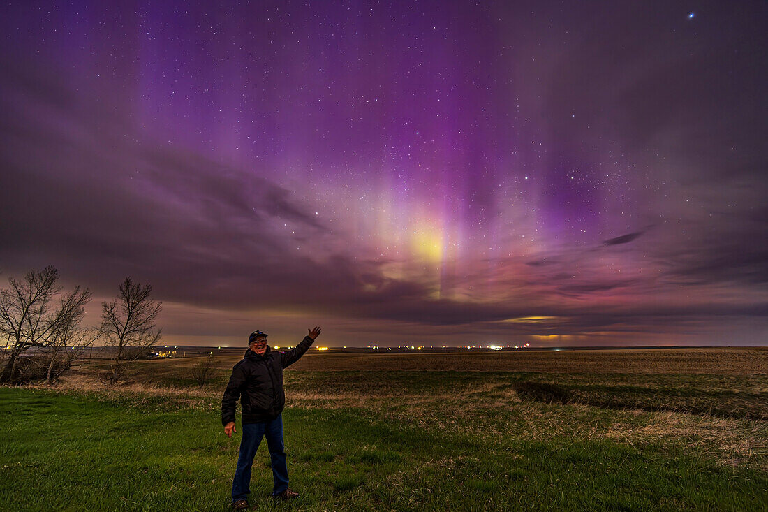 A selfie of me at the start of the great aurora show of May 10, 2024, with the aurora curtains still in the early evening twilight sky and looking very purple. Despite the clouds about.