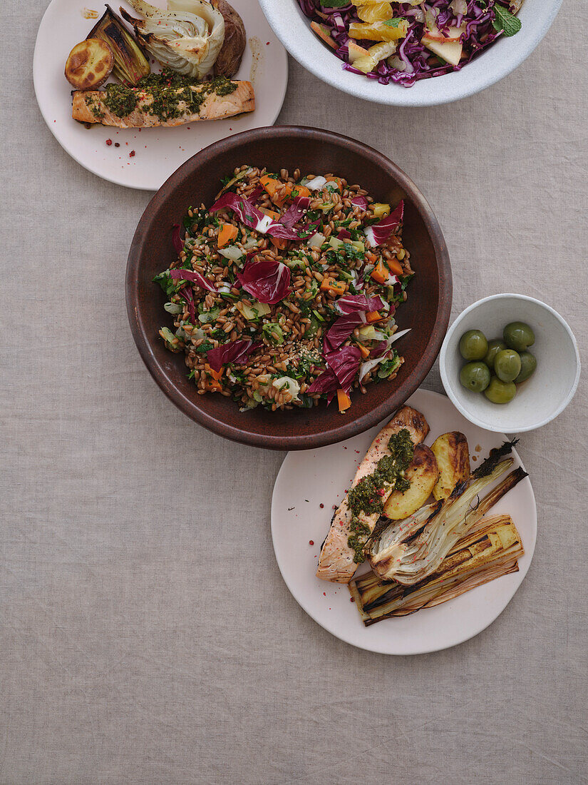 Draufsicht auf gesundes mediterranes Gericht mit Dinkelsalat, gegrilltem Lachs, Lauch und grünen Oliven