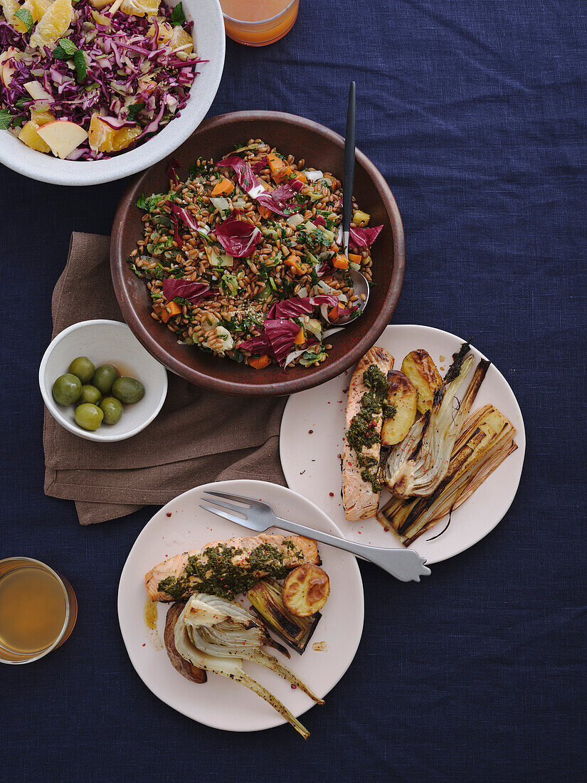 Table top view of gourmet Mediterranean food, including grilled salmon, salad and vegetables