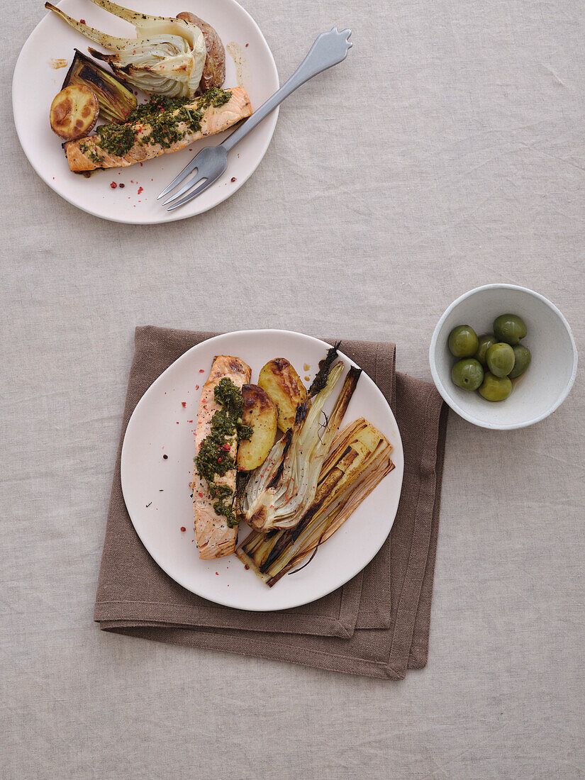 Still life view from above healthy meal of grilled salmon and leeks with green olives