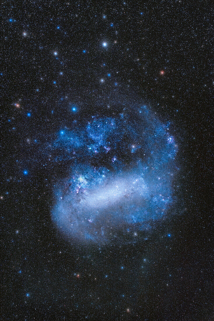 Dies ist die Große Magellansche Wolke, eine Satellitengalaxie der Milchstraße und Mitglied der Lokalen Gruppe von Galaxien, eingerahmt im Hochformat, um die gesamte Wolke und einige der schwächeren, entlegenen Glühwürmchen und umgebenden Sterne von Mensa und Dorado zu zeigen.