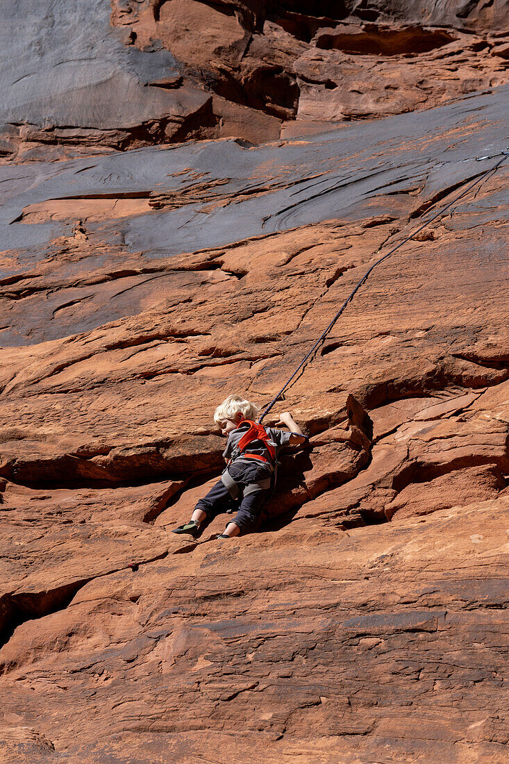 A young boy, age 3, learning to rock climb in Hunter Canyon near Moab, Utah.