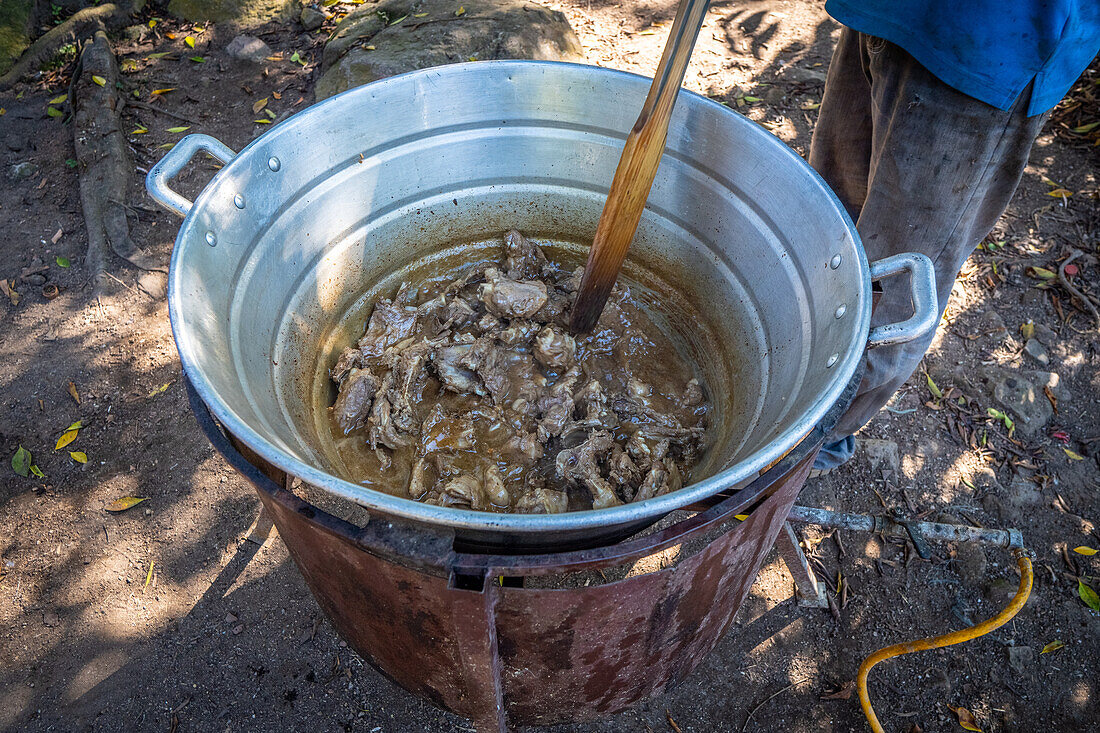 Ein Mann stellt in seinem Haus in Hoja Blanca, Guatemala, hausgemachte Schweineschwarte her.