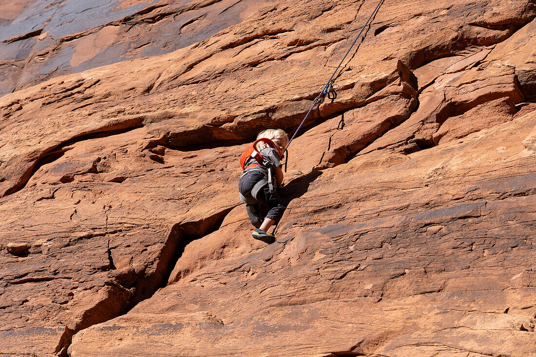 A young boy, age 3, learning to rock climb in Hunter Canyon near Moab, Utah.