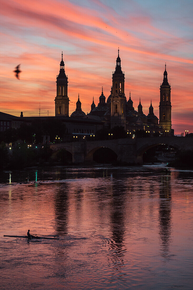 Cathedral-Basilica of Our Lady of the Pillar and kayaker on the Ebro River at sunset, Zaragoza, Spain