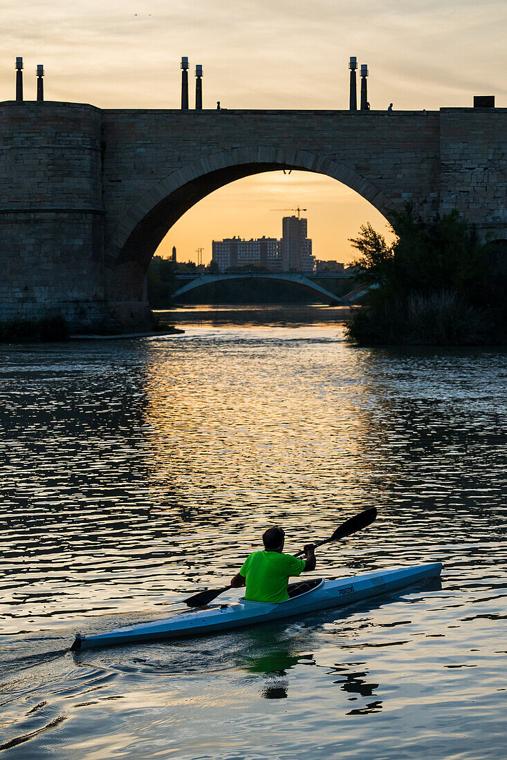 Kajakfahrer bei Sonnenuntergang auf dem Fluss Ebro, Zaragoza, Spanien