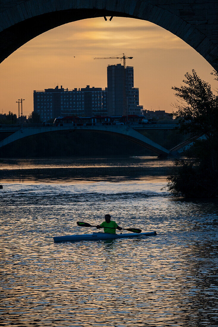 Kajakfahrer bei Sonnenuntergang auf dem Fluss Ebro, Zaragoza, Spanien