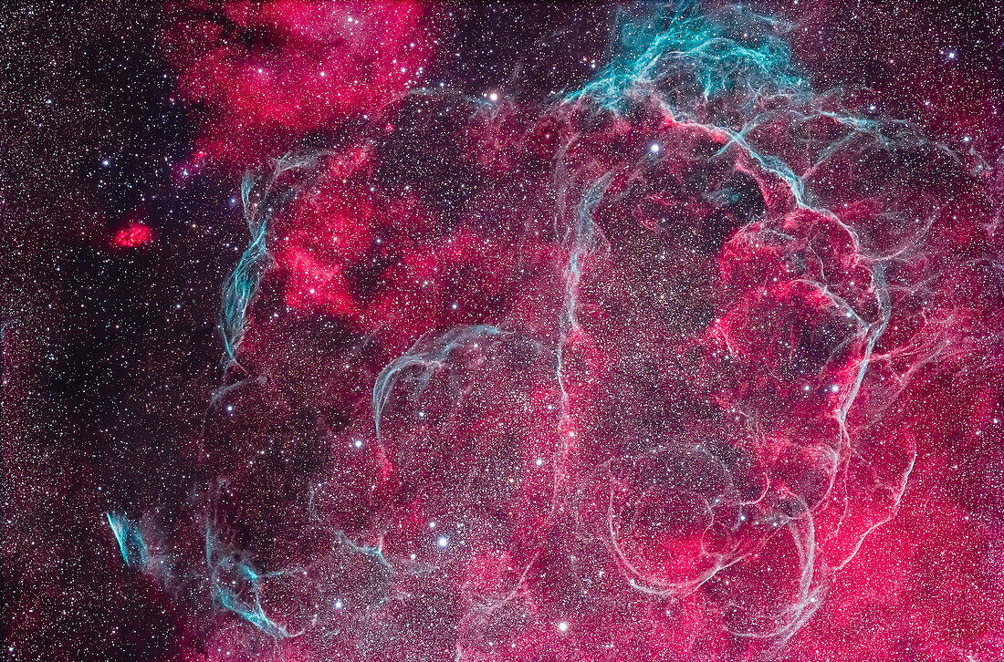 This frames most of the intricate arcs and loops of the Vela Supernova Remnant (SNR), the remains of a star that exploded about 11,000 years ago. It is one of the closest SNRs to Earth, about 900 light years away. Most arcs and segments have no separate catalogue numbers, with the exception of the short straight Pencil Nebula, aka Herschel's Ray, in the lower left corner which is NGC 2736. It is the brightest segment of the Vela SNR visually in a telescope. The nebula complex is marked with lots of cyan arcs emitting oxygen III wavelengths, mixed with regions of red hydrogen-alpha emission.